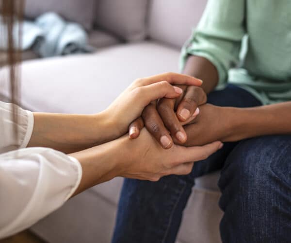 Photo of counselor holding a patient's hands