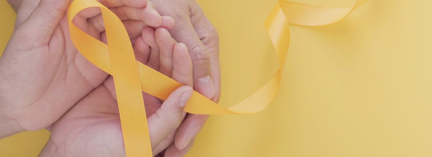 adult and child hands holding yellow gold ribbon, Sarcoma Awareness, Bone cancer, childhood cancer awareness, world suicide prevention day, September Yellow