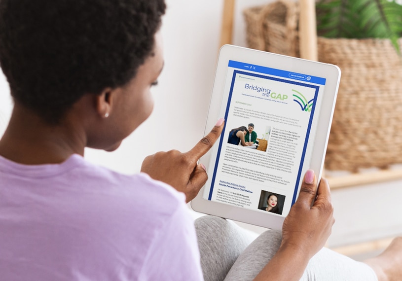 Image of an African American woman viewing the National Center newsletter on a tablet.