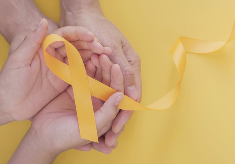 Image of two sets of hands holding a yellow ribbon in support of Suicide Prevention Month