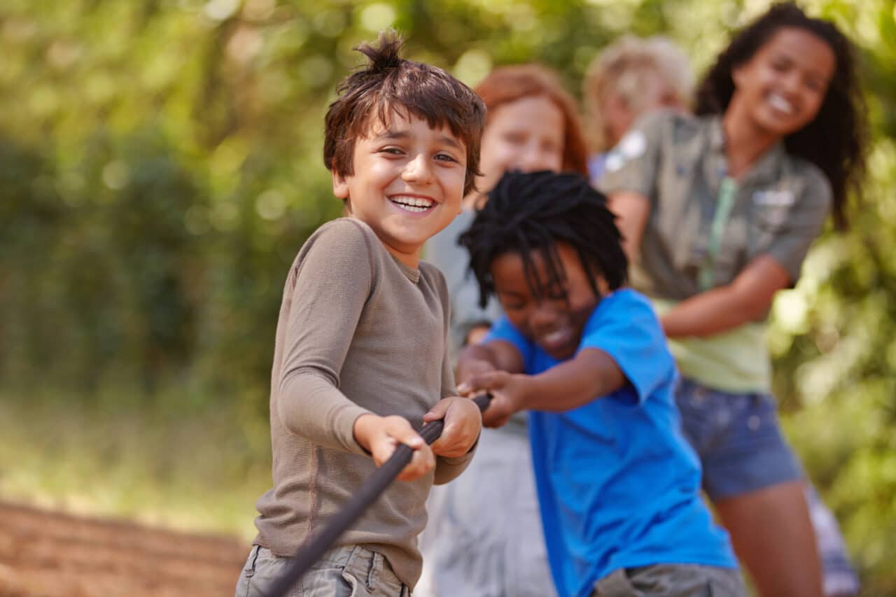 Learning teamwork through play. A group of kids in a tug-of-war game.