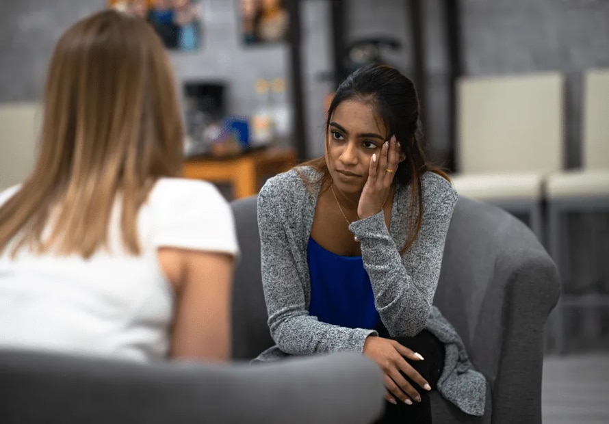 Image of a distraught young woman in a counseling session.